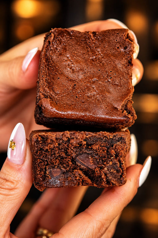 Two Frato's triple chocolate brownies from the 2 lb gift box, held to show the fudgy inside
